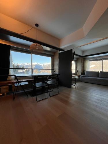 a living room with a table and chairs and a couch at Suite 1400 in Marilleva