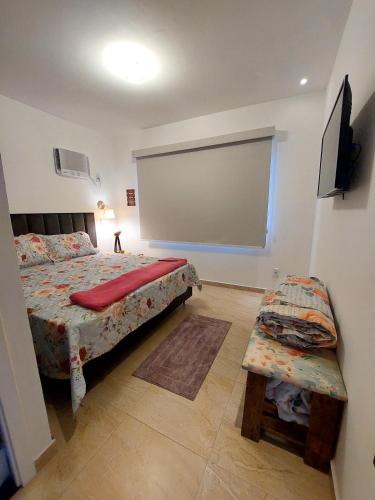 a bedroom with a bed and a large screen at Studio Nosso Sonho in Cabo Frio