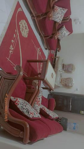 a wooden chair with red cushions on a table at قرية الجندول بالاسماعلية طريقة البلاجات in Ismailia