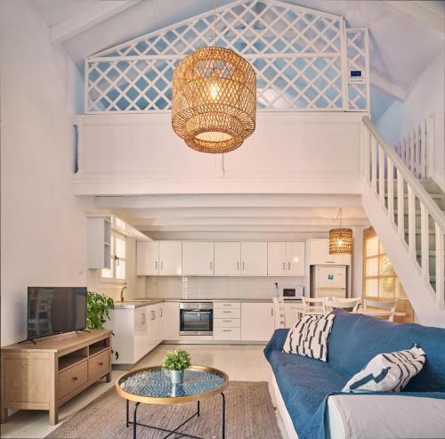 a living room with a blue couch and a table at Villa Erato Periyali in Vasilikos