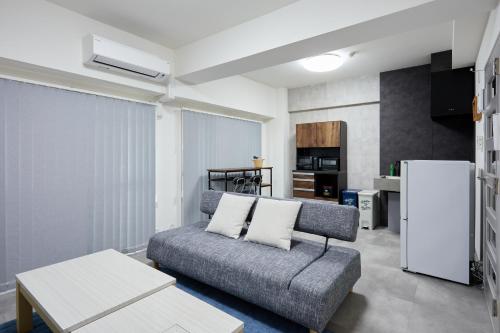 a living room with a couch and a refrigerator at エクセレンス大阪城公園 Osaka Castle Suite - Best for Cherry Blossoms & Park Views - Central Stay in Osaka