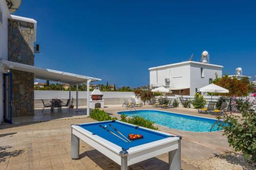 a pool table in front of a swimming pool at Villa Galazio by Villa Plus in Argaka