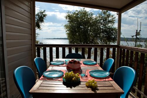 a wooden table with plates and bowls of fruit on a porch at Campeggio Europa Silvella in San Felice del Benaco