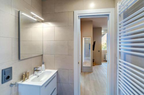 Un baño blanco con lavabo y espejo. en Cris by Totiaran, en Baqueira Beret