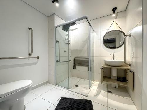 a bathroom with a glass shower and a sink at Vila Mariana - Conforto e Praticidade in Sao Paulo