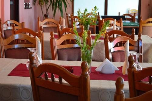バリウグにあるPensiunea Danielsのダイニングルーム(テーブル、赤いテーブルクロス、椅子付)
