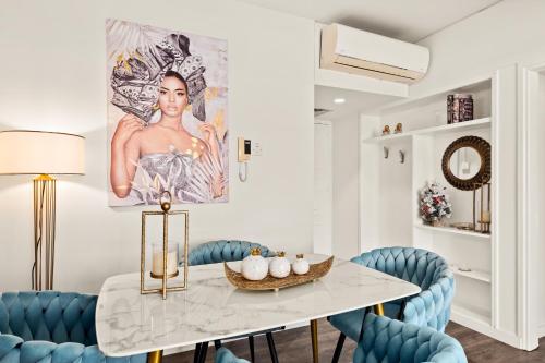 a dining room with a table and blue chairs at Lazuli Sea View Beachfront Ap 254 in Larnaca