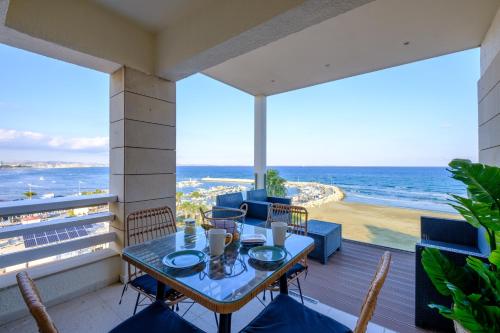 a table on a balcony with a view of the ocean at Lazuli Sea View Beachfront Ap 254 in Larnaca