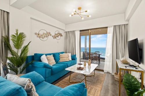 a blue couch in a living room with a view of the ocean at Lazuli Sea View Beachfront Ap 254 in Larnaca