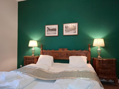 two beds in a green room with two lamps at Europe-Gastein in Bad Gastein