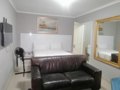 a living room with a leather couch and a mirror at The Afropolitan in Johannesburg