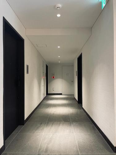 an empty hallway with white walls and black doors at Alo BnB 9 - Near ROPPONGI, GINZA, SHINJUKU, SHIBUYA - Self check-in in Tokyo