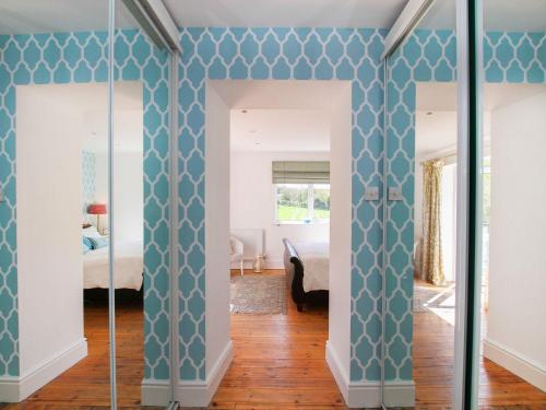 a room with blue and white walls and a bedroom at Goleufryn in Beaumaris