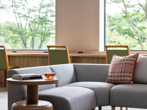 a living room with a couch and a table at Mitsui Garden Hotel Kashiwa-no-ha Park Side - Chiba in Kashiwa