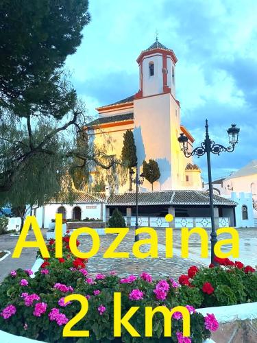 a building with a clock tower and flowers with the words albuquerque nm at Castle Tower apartment PICASSO in rural holiday park in Tolox