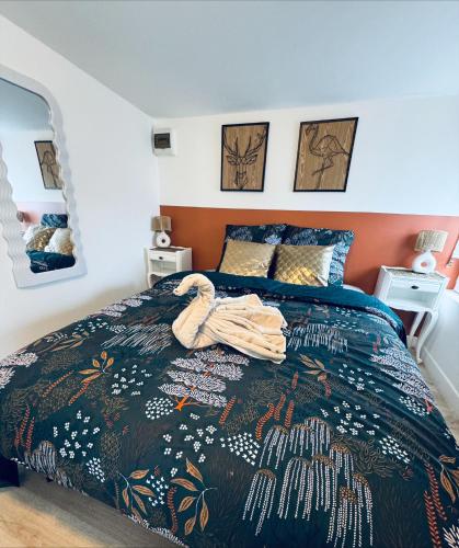 a bedroom with a bed with a blanket on it at Le Cocon de la Baie in Pontorson
