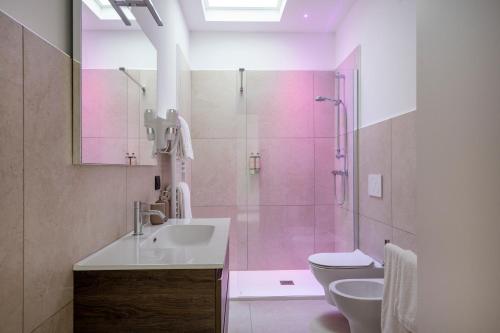 um banheiro com chuveiro, pia e vaso sanitário em Porta San Biagio - rooms & apartments em Matera