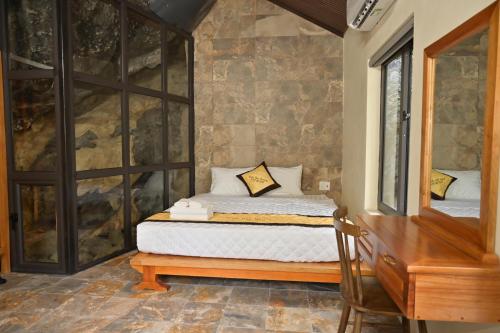 a bedroom with a bed and a dresser in a room at Ninh Hoa Retreat in Nguyên Ngoại