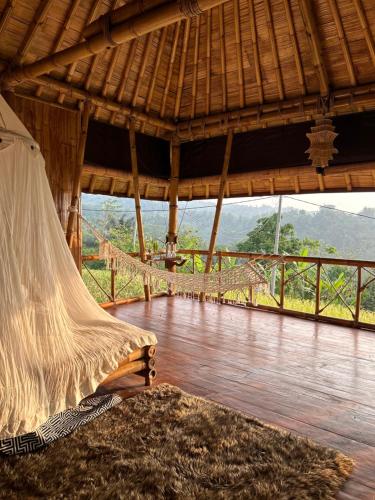 a hammock in a room with a view of the mountains at Tengah Uma Villa Sangketan in Tabanan