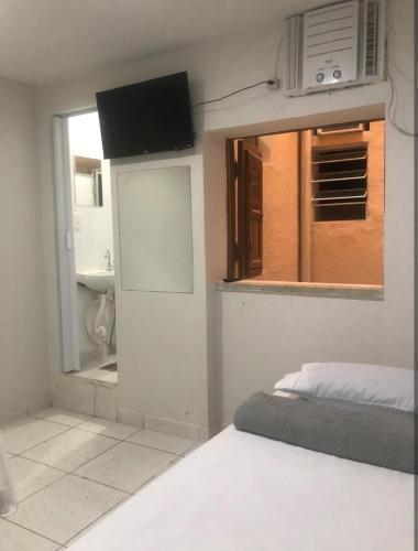 a bedroom with a bed and a window and a sink at Suíte 304 - Pousada no Centro do Rio in Rio de Janeiro