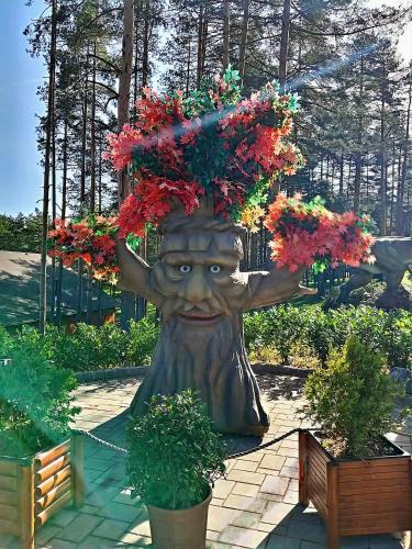 a statue of a tree with flowers on its head at Silver Star Zlatibor in Zlatibor
