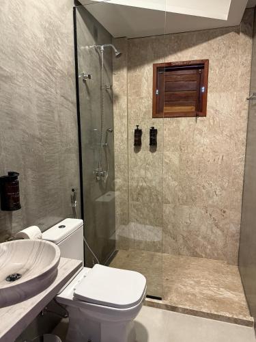 a bathroom with a shower and a toilet and a sink at Recanto Diamantino in Morro do Chapéu