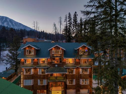 a large apartment building with a blue roof at Hotel Pine Spring Gulmarg in Gulmarg