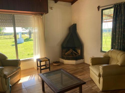a living room with a couch and a fireplace at Casa de campo in Termas de Guaviyu
