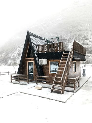 a log cabin in the snow with a staircase at Komarnica Forest Owl in Šavnik
