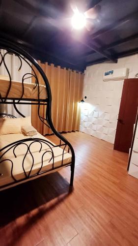 a room with a bunk bed with a wooden floor at The Cozy Glass House by the Sea in Bauang