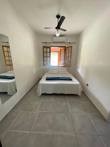 a bedroom with a bed and a ceiling fan at Pousada Chácara Sonho in Hortolândia