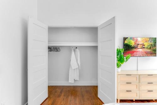 una stanza bianca con un armadio e una TV di 20 MIN to Manhattan! 2BR Luxurious Comfy & Spotless a Newark