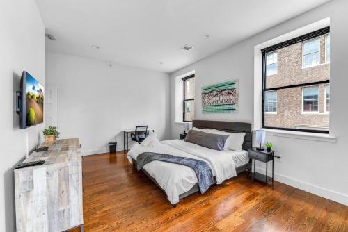 una camera da letto bianca con un letto e una finestra di 20 MIN to Manhattan! 2BR Luxurious Comfy & Spotless a Newark