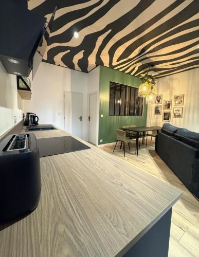 d'une cuisine et d'un salon avec un plafond à motifs zébrés. dans l'établissement Studio Savane, 6 min du Zoo, à Seigy