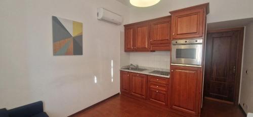 a kitchen with wooden cabinets and a stove top oven at Le Casasse Ca' Parodi 7 in Varigotti