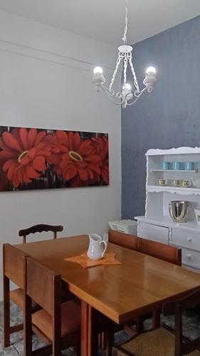 a dining room with a table and a chandelier at Apartamento privativo aconchegante in São Gabriel