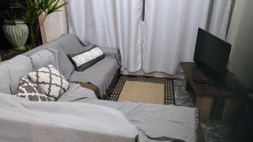 a living room with a couch and a television at Apartamento privativo aconchegante in São Gabriel