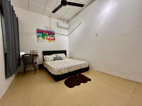 a bedroom with a bed and a table with a chair at Home10perwira#6pax#netflix#simpangampat#neariconicpoint in Simpang Ampat