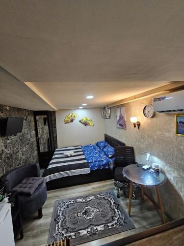a bedroom with a bed and a couch and a table at different house in Tbilisi City