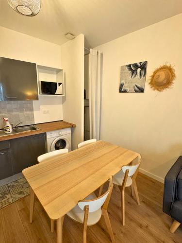 une salle à manger avec une table et des chaises en bois dans l'établissement Les Arcades - WiFi - Spacieux - Centrale, à Dax