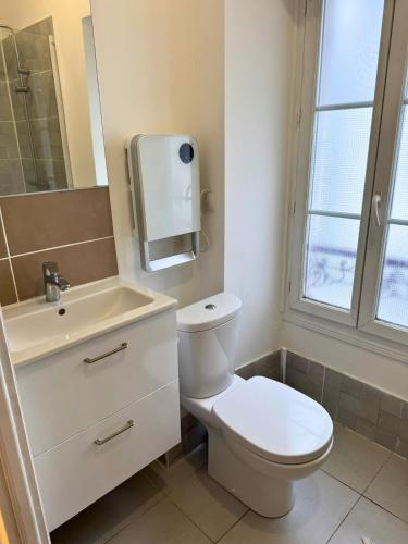 une salle de bain avec des toilettes blanches et un lavabo dans l'établissement Les Arcades - WiFi - Spacieux - Centrale, à Dax
