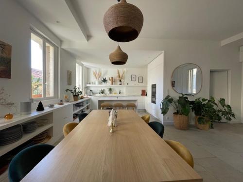 - un grand salon avec une table et des chaises en bois dans l'établissement Vaste et Bel Appartement en plein Centre-ville de Montpellier, à Montpellier