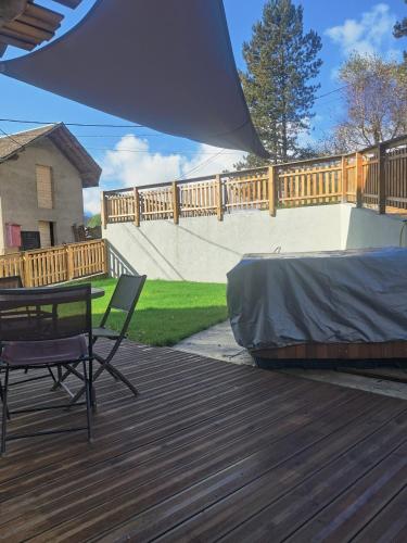 d'une terrasse avec une table et une chaise. dans l'établissement Appartement 38m2 cadre champêtre, à Taninges