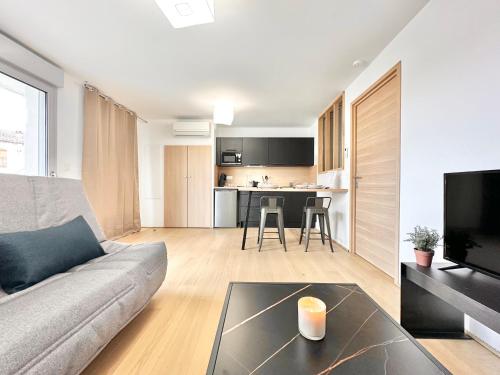 a living room with a couch and a table at Au Cœur de la Médina - Centre Ville - Parking in Mont-de-Marsan