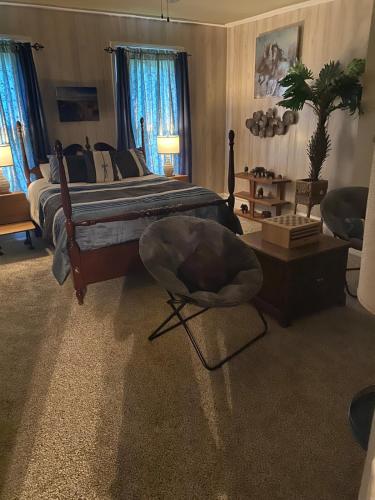a bedroom with a bed with a chair and a table at Charming Wheeling Island Home in Wheeling