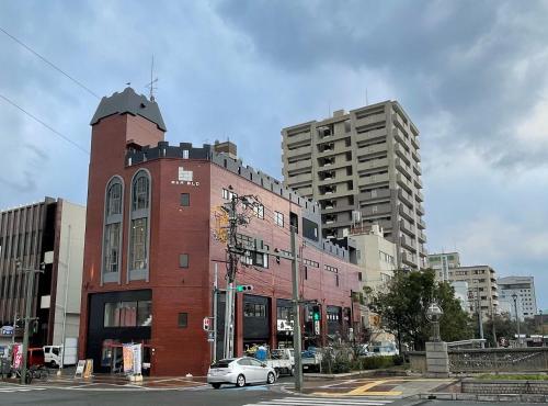 a red brick building on a city street with buildings at Red Submarine in Kure