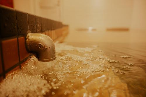 a water faucet in a bath tub filled with water at Red Submarine in Kure