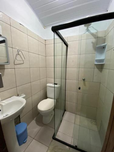a bathroom with a toilet and a glass shower at Hostel Rota Itacaré in Itacaré
