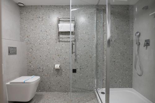 a bathroom with a glass shower with a toilet at REST INN apart hotel in Cherkasy