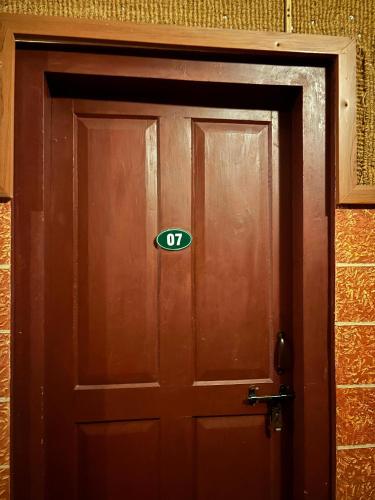a wooden door with a sign on it at Cure Monastery Family Resort in Marayoor